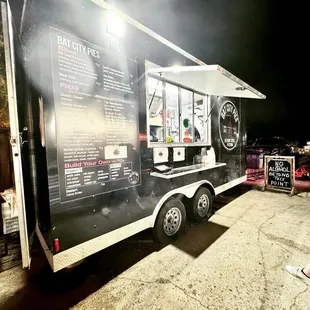 a woman standing in front of a food truck