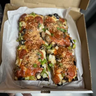 a hand holding a box of pizza