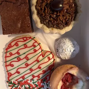 Frosted sugar cookie, salted Carmel brownie, bourbon pecan pie tart, Russian tea cake and cherry cheesecake tart.