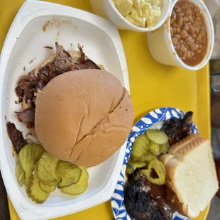 Rib and brisket sandwich with baked beans and potatoe salad sides.