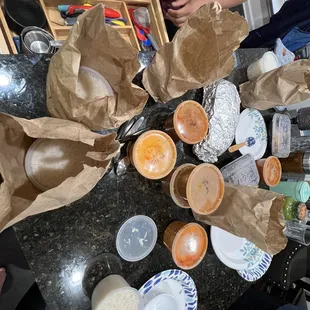 a group of people sitting around a table with bowls of food