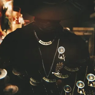 a man wearing a hat and necklace