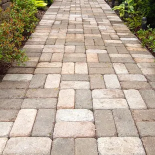 a brick walkway in a garden