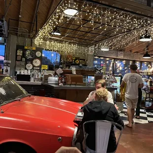 a red car parked in front of a bar