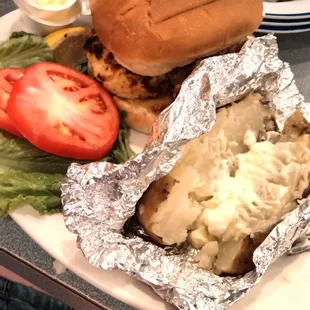 Grilled chicken breast sandwich and baked potato.