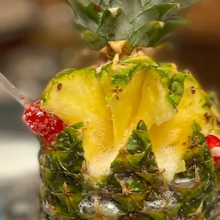 a pineapple drink with a straw and a garnish