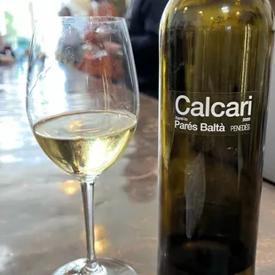 a bottle of calucan and a glass of wine