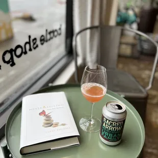 a glass of wine and a book on a table