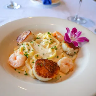 scallops, scallops, and pasta on a white plate