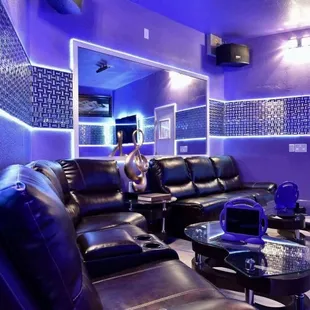 a purple living room with black leather furniture