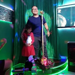 a man and a little girl standing in front of a microphone