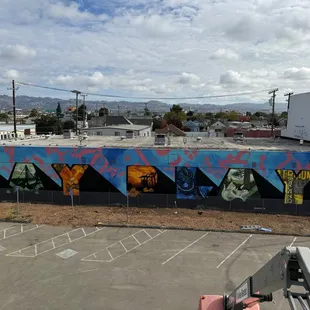 The mural and overview of the building and parking lot
