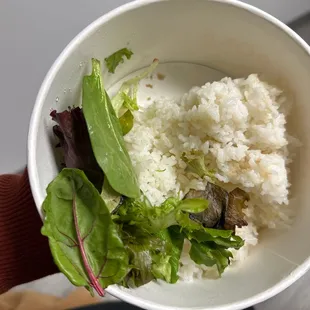 a bowl of rice, lettuce, and greens