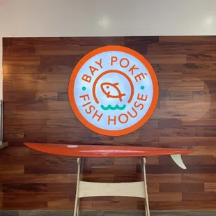 a surfboard on a table in front of a wooden wall