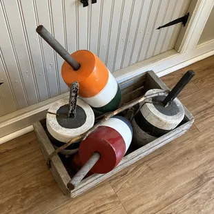 a wooden box filled with colorful buoys