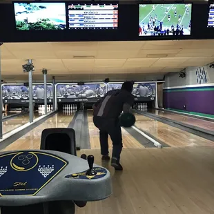 a man bending over to pick up a bowling ball