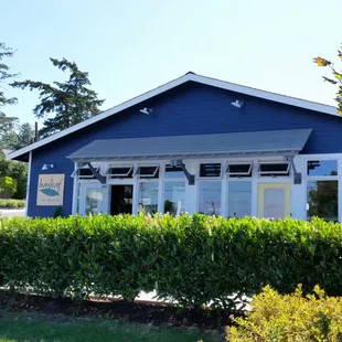 the front of a blue house with a white trim