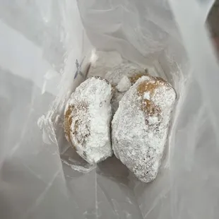 two powdered donuts in a plastic bag