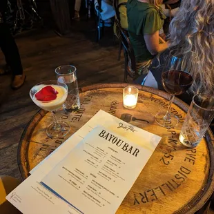 a menu and wine glasses on a barrel