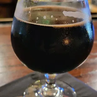 a glass of beer on a napkin