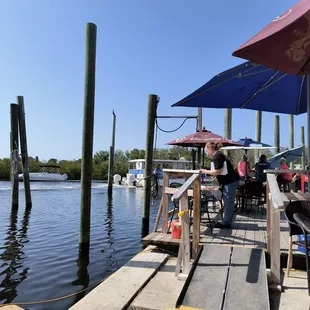 a woman standing on a dock with an umbrella over her head