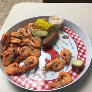 a plate of shrimp, corn, and potatoes