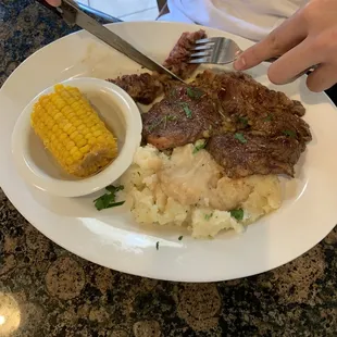Ribeye steak with mashed potatoes and corn