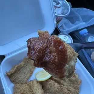 a hand holding a piece of fried chicken