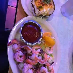 two plates of seafood and a side dish