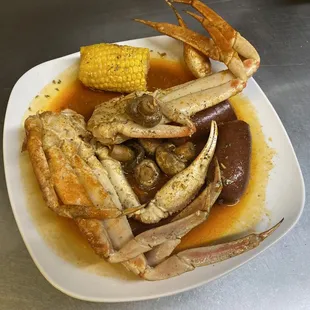 Boiled snow crab with boiled corn, mushrooms, and sausage