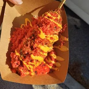 Cheesedog with hot cheeto topping and all the sauces