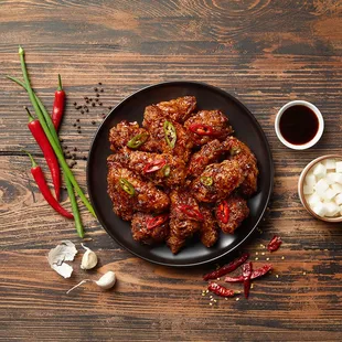 a plate of chicken wings with chili and garlic