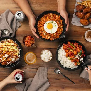  three people holding pans of food