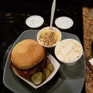 Pulled pork sandwich with some homemade pickles, mac n cheese, and cole slaw