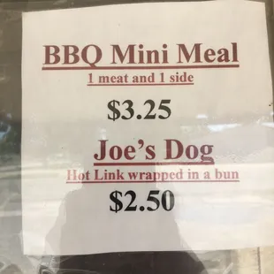 a sign in a window saying $ 2 25 joe's dog hot link wrapped in bun $ 2 50