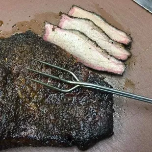 a steak and a fork on a cutting board