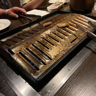 people sitting at a table with a grill