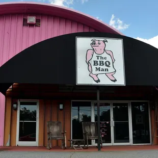 a pink building with a black awning