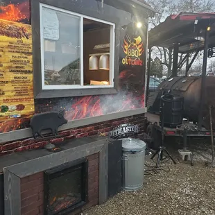 a bbq truck with a fire in the background