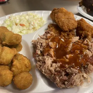 a plate of meat, tater tots, and coleslaw