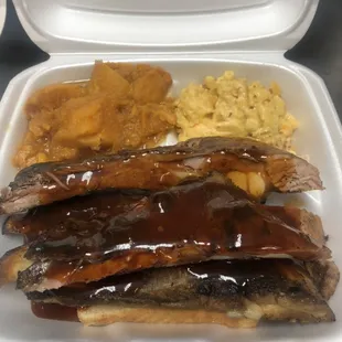 Pork long ribs smothered in barbecue sauce with candied yams and baked Mac&amp;cheese