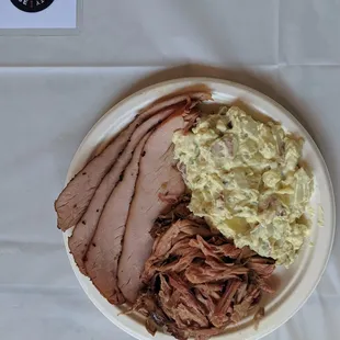 a plate of pulled pork, mashed potatoes, and coleslaw