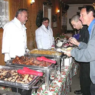 a group of people standing around a buffet table