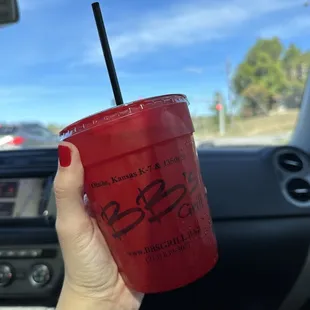 a person holding a red cup with a straw