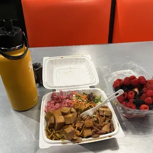 Yakisoba (main side - under protein), cabbage salad (pink side), mixed green salad (green salad).  Protein:  half spicy chicken, half tofu.