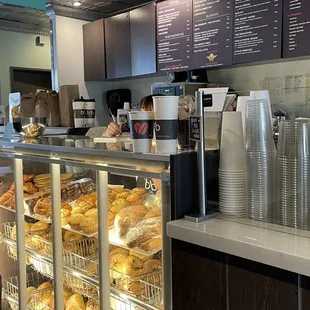 Front counter; fresh baked bagels and muffins on display with available discounted bags of &quot;day-old&quot; bagels