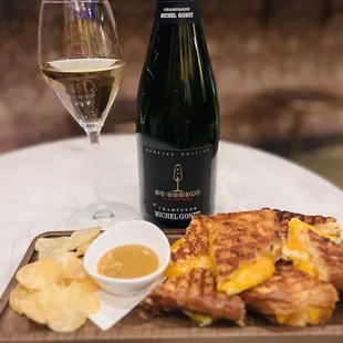 a glass of wine and a grilled cheese sandwich