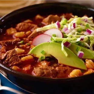 a bowl of chili with meat and avocado