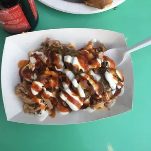 A beautiful basket of pulled pork mac n cheese topped with jalapeño and sour cream!