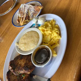 Pork chops, cheese grits, eggs and French toast.